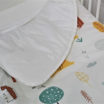 Colchão para berço com tecido estampado e cobertor branco