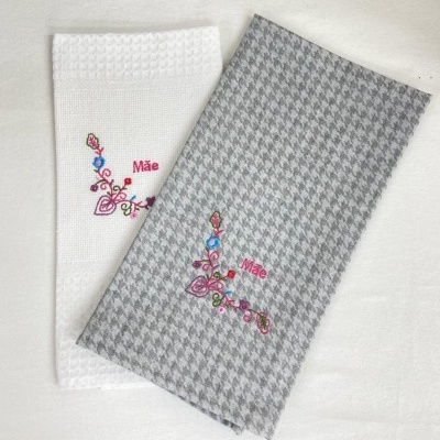 Dois panos de cozinha com bordado floral e texto 'Mãe'