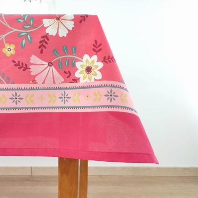 Toalha de mesa rosa com padrão floral sobre mesa de madeira