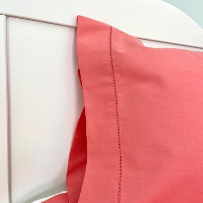 Travesseiro com fronha coral e cabeceira branca