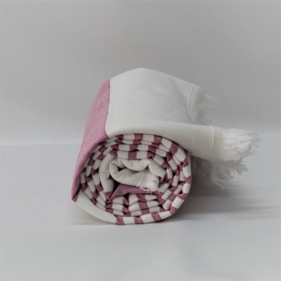 Manta ou toalha enrolada com padrão às riscas rosa e branco com franjas