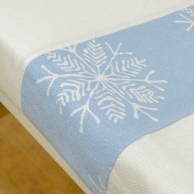Toalha de mesa branca com barra azul clara e flocos de neve brancos
