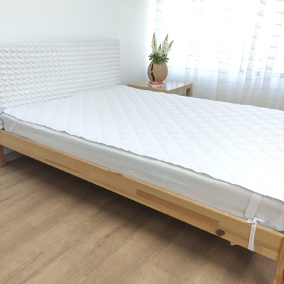 Cama de madeira com colchão branco e cabeceira geométrica em ambiente minimalista