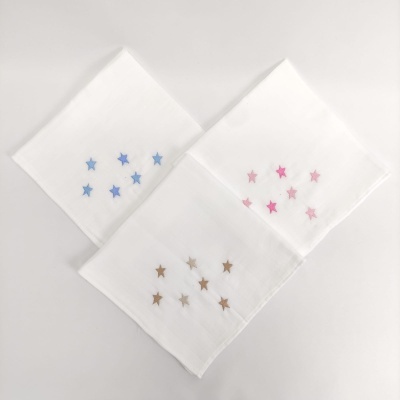 Três lenços brancos com estrelas bordadas em azul, rosa e castanho