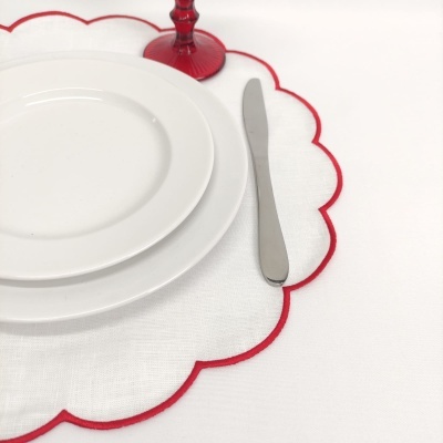 Conjunto de pratos brancos com guardanapo vermelho e utensílios na mesa