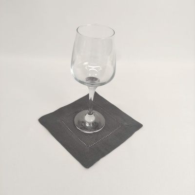 Copo de vinho transparente sobre porta-copo cinza de tecido