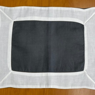 Toalha de mesa retangular preta e branca sobre mesa de madeira