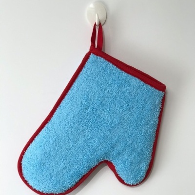 Luva de cozinha azul pendurada na parede branca