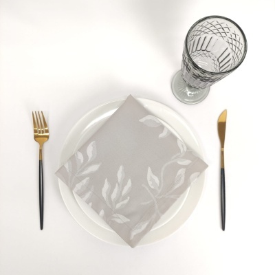 Conjunto elegante de mesa com prato, guardanapo, talheres dourados e copo de vidro