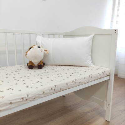 Berço branco para bebé com colchão, almofada branca e peluche de vaca