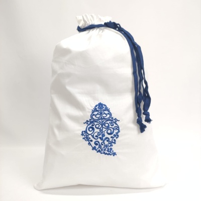 Saco branco em tecido com cordão azul escuro e padrão azul ornamental no centro