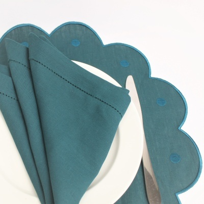 Conjunto de guardanapo e porta-talheres azul esverdeado com padrão circular e prato branco