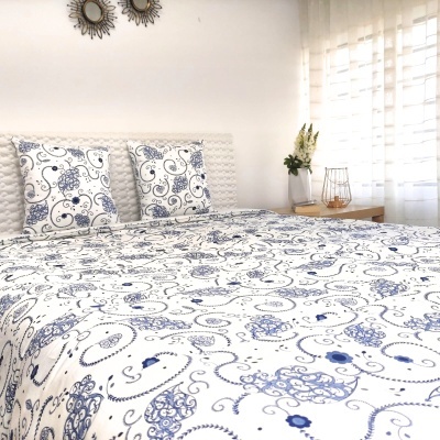 Cama com fronhas e lençol brancos com estampado floral azul