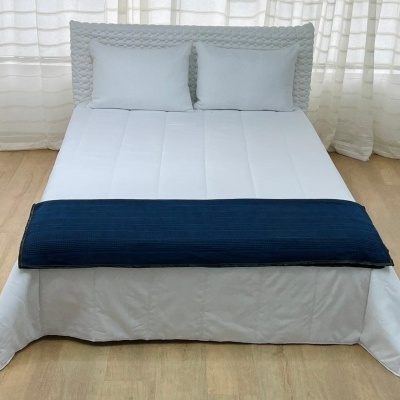 cama de casal com roupa de cama branca e manta azul escura