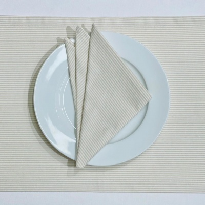 Jogo americano bege com riscas brancas e prato branco com guardanapo