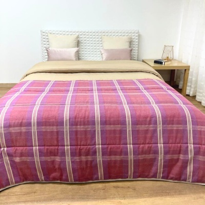 Cama com colcha rosa às riscas e decoração minimalista