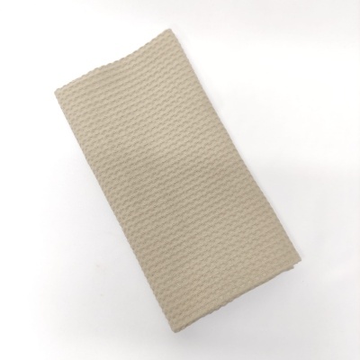 Toalha bege com textura ondulada sobre fundo branco