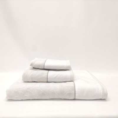 Conjunto de três toalhas brancas com padrão texturizado empilhadas