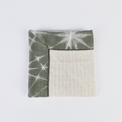 Guardanapo têxtil verde e bege com padrão e textura visível