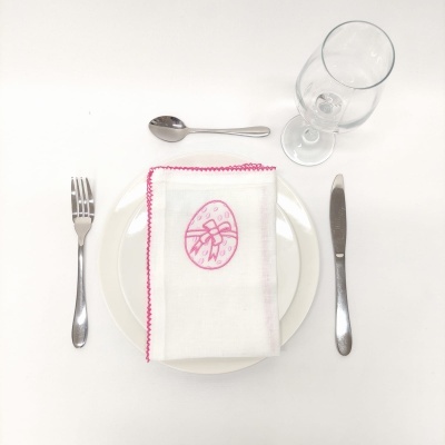 Conjunto de talheres, prato com toalha branca decorada em rosa e copo de vidro