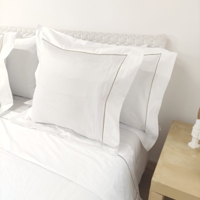 Conjunto de roupa de cama branco com fronhas decoradas com linha cinza