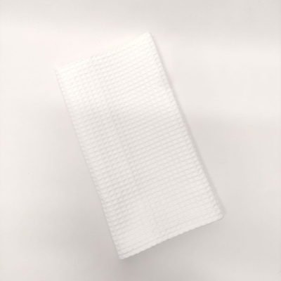 Toalha branca texturizada sobre superfície branca