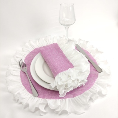 Jogo americano e guardanapo rosa com bordas brancas onduladas, prato branco, talheres de metal e copo de vidro