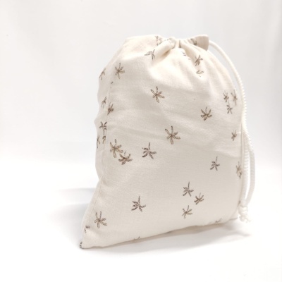 Saco branco com pequenas aranhas bordadas e fecho de cordão