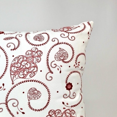 Almofada decorativa branca com padrão vermelho floral e arabescos