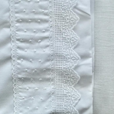 Tecido branco com bordado de renda e pequenos pontos texturizados