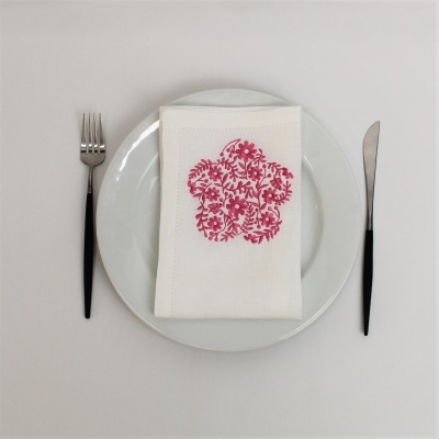 Talheres, prato e guardanapo branco com padrão floral vermelho