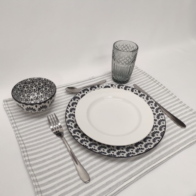 Conjunto de loiça com pratos, taça, copo, talheres e guardanapo às riscas