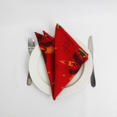 Guardanapo de natal vermelho dobrado no prato com talheres ao lado