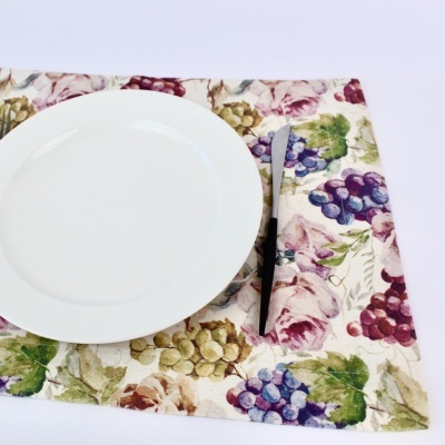 Conjunto de mesa com padrão de uvas, prato branco redondo e faca prateada