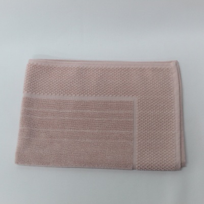 Toalha de banho rosa claro dobrada com textura malha