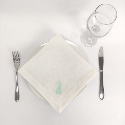 Talheres, prato branco, guardanapo branco bordado e copo transparente