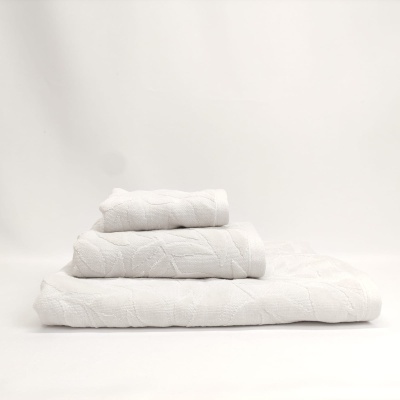 Três toalhas brancas empilhadas com padrão geométrico