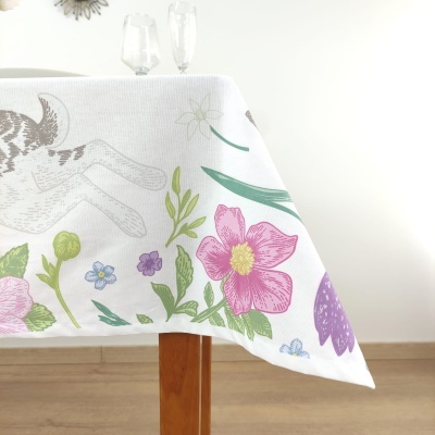 Toalha de mesa branca com flores coloridas sobre mesa de madeira clara