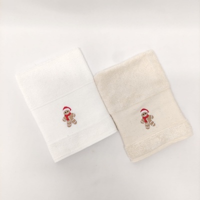 Duas toalhas de banho brancas e bege com bordado de boneco de gengibre natalício