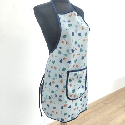 Avental branco com padrão de folhas coloridas e bolso azul escuro