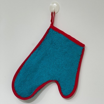 Luva de cozinha azul com bordas vermelhas pendurada na parede