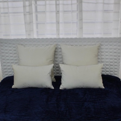 Cama com almofadas brancas e colcha azul escura