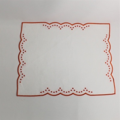 Toalha de mesa branca com bordado vermelho e padrão ondulado.