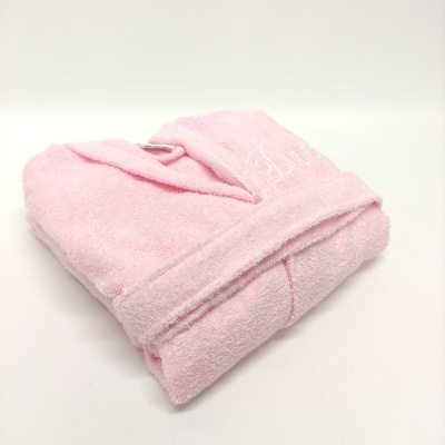 Robe de banho rosa dobrado em superfície branca