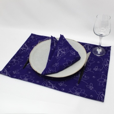 Conjunto de mesa com individual e guardanapo azul com padrão floral branco, prato, talheres e copo