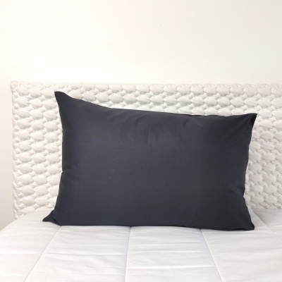 Almofada preta sobre cama branca acolchoada