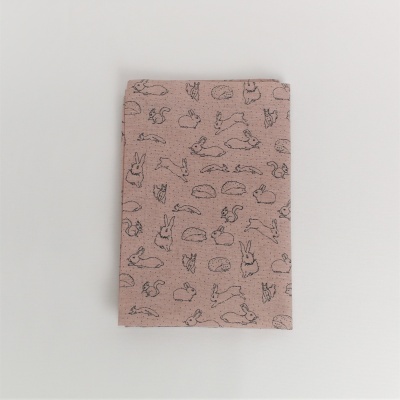 Caderno com capa rosa bege estampada com padrões de animais e formas geométricas