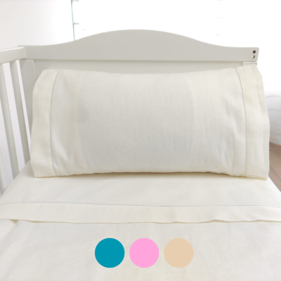 Cama branca para bebé com almofada e fronha branca lisa.