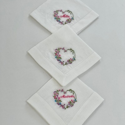 Três lenços brancos bordados com corações florais e texto em vermelho