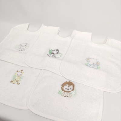 Cinco babetes brancos para bebé com bordados coloridos de animais.